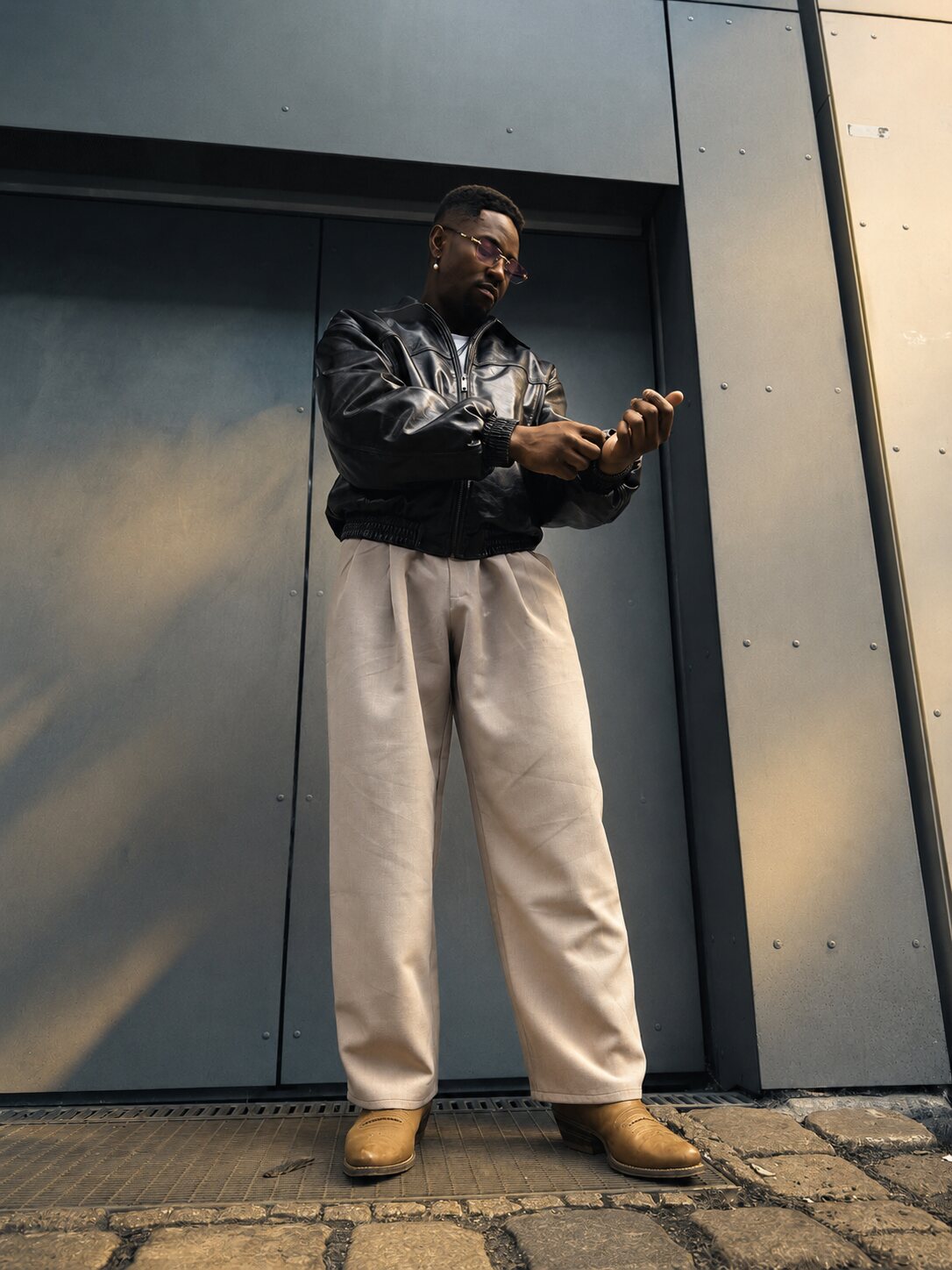 Mani Simon in a leather jacket against concrete
